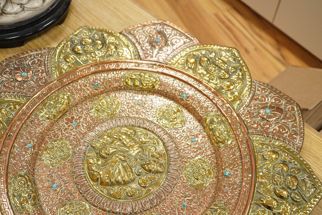 A large Nepalese brass and copper embossed tray, first half 20th century, set with simulated turquoise cabochons, 68cm diameter